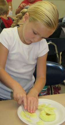 First graders turn apples into applesauce Emilie Moon cuts and peels apples in Mrs. Amy Ross’ first-grade class at Delaware Valley Elementary School. (Photo provided)
