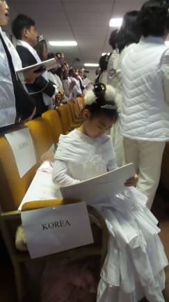 Gun-wielding couples renew their vows A child sat drawing during the blessing and ceremonies (Photo by Frances Ruth Harris)