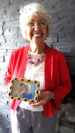 Denise Smithson holds a photo of herself with her sponsor and friend of 60 years, Norma Andriani.