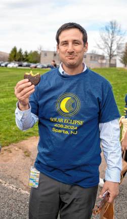 Sparta Middle School Principal Frank Ciaburri eats a Moon Pie at the eclipse watching event. (Photo by Nancy Madacsi)