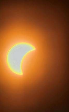 Residents gather to view partial solar eclipse The moon covers part of the sun Monday afternoon, April 8, as seen from the Wallkill River National Wildlife Refuge in Sussex. (Photo by Gulbadan Habibi)