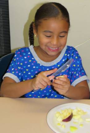 First graders turn apples into applesauce Xiomara Rosario cuts and peels apples in Mrs. Amy Ross’ first-grade class at Delaware Valley Elementary School. (Photo provided)