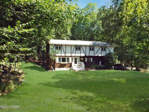 Country home has beautiful wooded views, lake access, flexible living space
