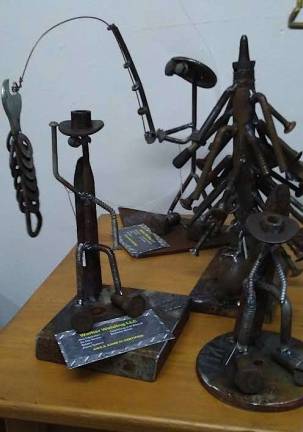 Whimsical fishermen and seated figures make up the collection of Walker Welding salvage sculptures at the Milford Craft Show