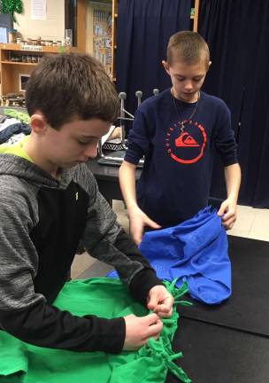 'Odyssey Angels' make totes for food pantries Delaware Valley Middle Schools Odyssey of the Mind technical team members John-Lockwood (left) and Cole Miller tie fringes together (Photo provided)