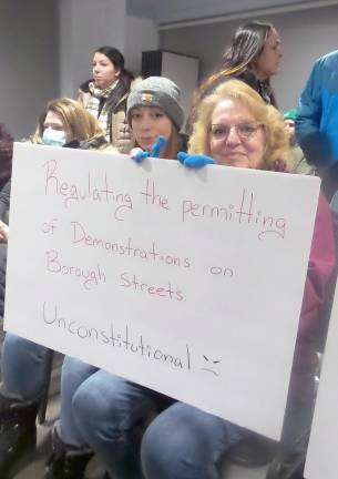 Helen Kushner holds a sign expressing her view (Photo by Frances Ruth Harris)