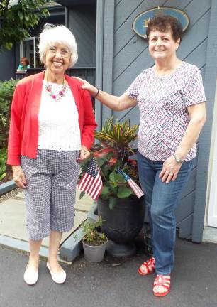 Denise Smithson with Gail Darcy outside her home in Raspberry Ridge, with welcoming American flags in the planter.