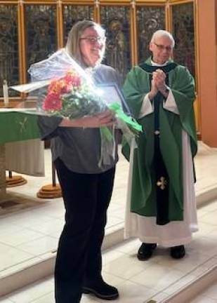 Mary Caraballo is presented with flowers.