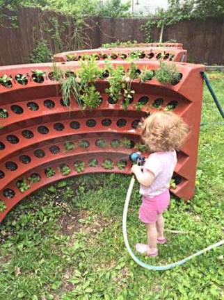 Here's a sneak peek at the 2017 Kitchen Garden Tour Joely’s daughter, Zia, waters her vertical garden.