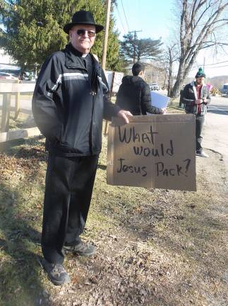 Gun-wielding couples renew their vows A protester outside the church (Photo by Frances Ruth Harris)