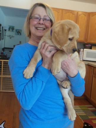 Benni, service dog in training, dazzles preschoolers Chrisanne Cubb and Benni back in February, when he first arrived in Milford (Photo by Frances Ruth Harris)