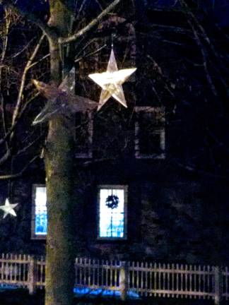 Santa arrives, the tree lights up, and all is well in Milford Star decorations hanging from one of the trees on Community House property (Photo by Anya Tikka)