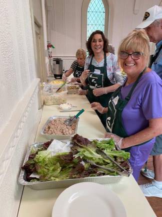 Volunteers Pat Rennish, right, and Phyllis Fernandez prepare lunch, which included tuna salad, five-bean salad, macaroni salad, deviled eggs, homemade desserts and more.
