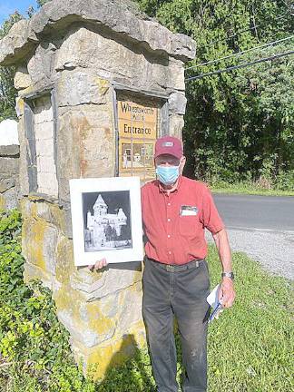 The Castle Keeper, 92-year-old Bob Allen, stands by one of the castle's Flint Faience tiles. When Allen was a lad, an 85-year-old gentleman proudly showed him the tile, which remains at the entrance to the castle. He said to Allen, See that tile with the man on the broom? That's me. (Photo by Laurie Gordon)