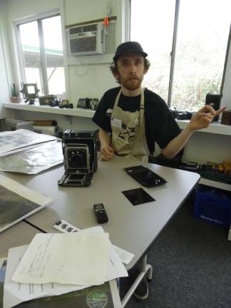 Locals get crafty Photography Fellow Kevin Bond sits with his antique speed graphic 4x5 camera to the other one near the door.