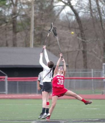 DVH Warriors defeat Hazleton Cougars in Girls Varsity Lacrosse A Delaware Valley Warrior and Hazleton Cougar reach skyward for the ball