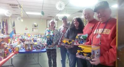 Erica Brennan, administrator for the project, DJ Knight, Deniece Closs, George Schmitt and Burt Weinstein are ready to shower families with toys. (Photo by Frances Ruth Harris)