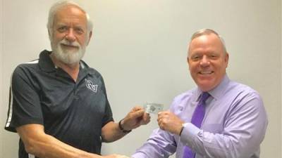 Delaware Valley School District Superintendent Dr. John Bell gives the first Senior Warrior card to Paul Gavoille, a 1970 DV graduate of DV and a member of the district's maintenance staff for more than 31 years.