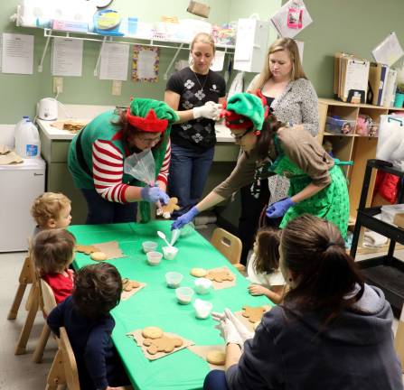 Elf-dieticians help children at CDD decorate gingerbread cookies Dietician Marisa Elliott (right) and Sous Chef Allison Wharton visited five classes in the CDD facility (Photo provided)