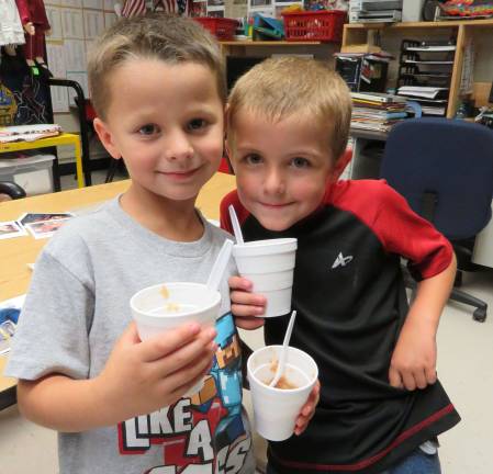 First graders turn apples into applesauce Zachary Copertino and Danny Pflanz, first graders in Mrs. Amy Ross’ Delaware Valley Elementary School class, enjoy homemade applesauce after it cooked all day in the classroom. (Photo provided)