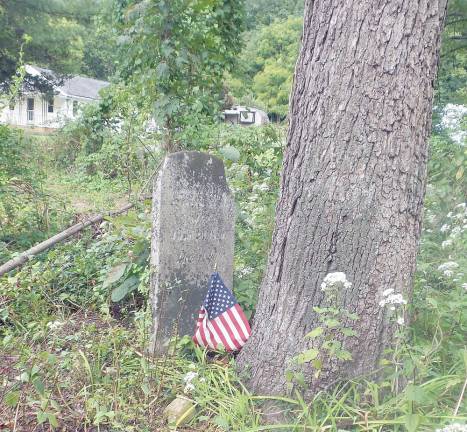 Old tombstone with new flag (Photo by Frances Ruth Harris)