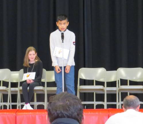 Mackenzie McAdam waits as Eddie Arias spells out the last word of the Bee.