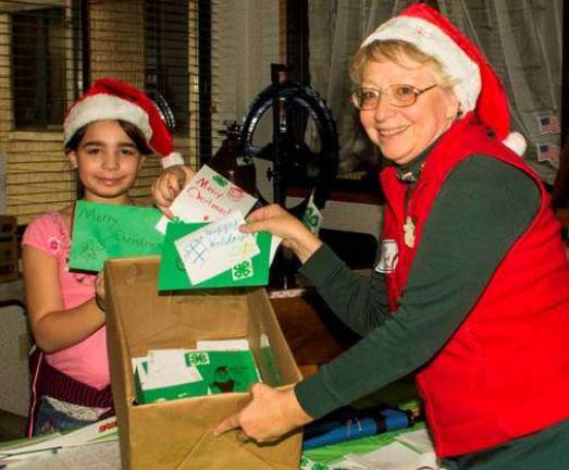Getting to know you Santa, Susan Ridyard, and elf, Autumn Hertz, are making sure there are enough happy holiday cards for every resident of Belle Reve Senior Living Center. (Photo: 4-H Photography Club Leader Jack de Geus)