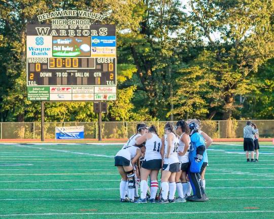 Field hockey players consult on the field