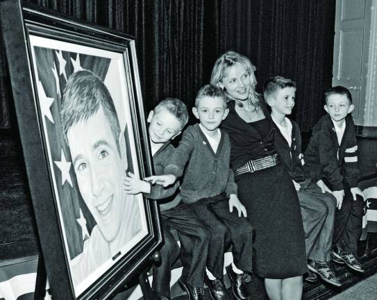 Petition seeks justice for Lou Allen Barbara Allen with sons Trevor, Collin, Sean and Jeremy gather together on the stage of the George F. Baker High School auditorium in Tuxedo Park next to the American Fallen Soldier Project painting of her late husband the children’s father First Lieutenant Lou Allen (2010). (Photo by Lt. Col. Paul Fanning, Joint Forces Headquarters-NY)