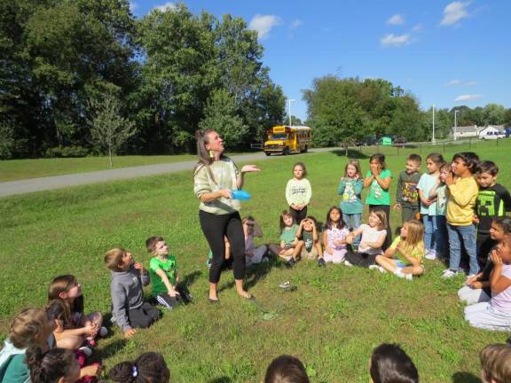 Delaware Valley first-grade teacher Kimberly Fountain releases Bob the butterfly as first grade students watch.