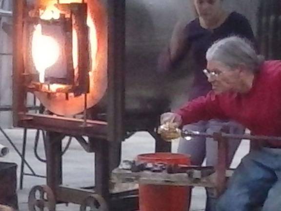 The art of glass blowing Cutting the blown glass into shape.