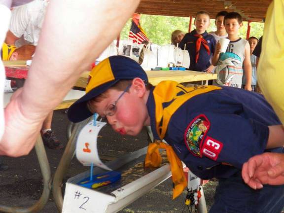 Cub Scout families end year with picnic, ceremony and races A Cub Scout races his boat in the annual rain gutter regatta. The boat cannot be physically touched, but must be completely propelled by the Scout blowing on the boat’s sail.