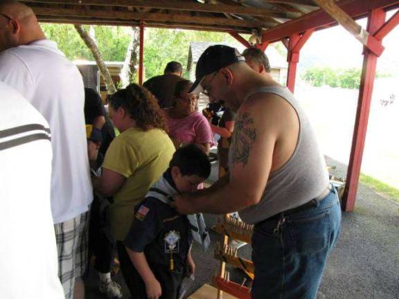 Cub Scout families end year with picnic, ceremony and races A Wolf Cub Scout and his father meet after the scout crosses over the bridge advancing him to the next level. This scout will now start on the journey towards earning his Bear Cub Scout rank, as his father places his blue neckerchief and slide on his uniform.