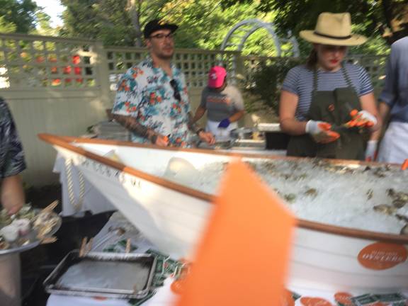 Chef Brandon Grimila shucks oysters next to Lindsay Howard of Island Creek Oysters