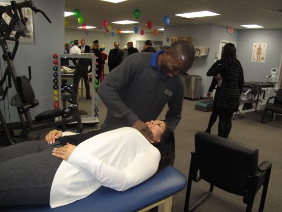 Access Physical Therapy celebrates opening of second PA location Innocent Rwakonda massages Ashley Kurtz in the new Dingmans Ferry facility. (Photo by Jerry Goldberg)