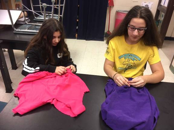 'Odyssey Angels' make totes for food pantries Scarlett Weir (left) and Elena Cirello tie fringes together (Photo provided)