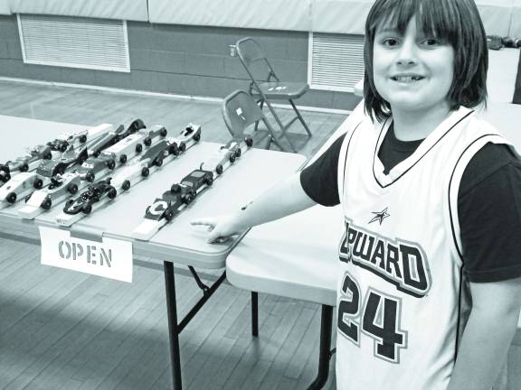 Race Time at the Pinewood Derby Connor Gaughan of Milford, points to the race car he made with the initial of his first name.
