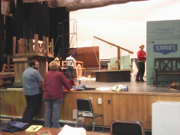 Curtain soon to go up on 'Fiddler' Putting up the set is stage manager and set designer Laura Walsh. Foreground: Alex Miller, who plays the main character, Tevye, chats with Director Kim Golden (Photo by Anya Tikka)