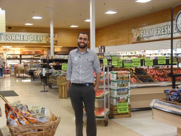 New supermarket owner cleans up Junior Dabashi amid the produce at Key Foods (Photo by Anya Tikka)