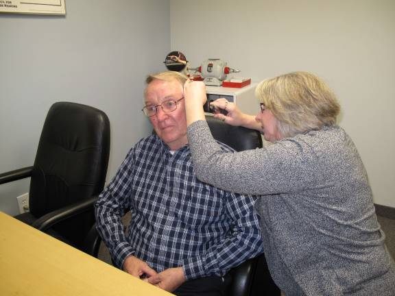 Access Physical Therapy celebrates opening of second PA location Hearing aid specialist Terri Sutherland busy examining patient Ray McGoo