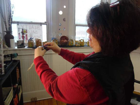 Partners who 'click' welcome customers to new salon Co-owner Susan Brown demostrates how to change stones in the magnetic jewelry the boutique carries (Photo by Anya Tikka)