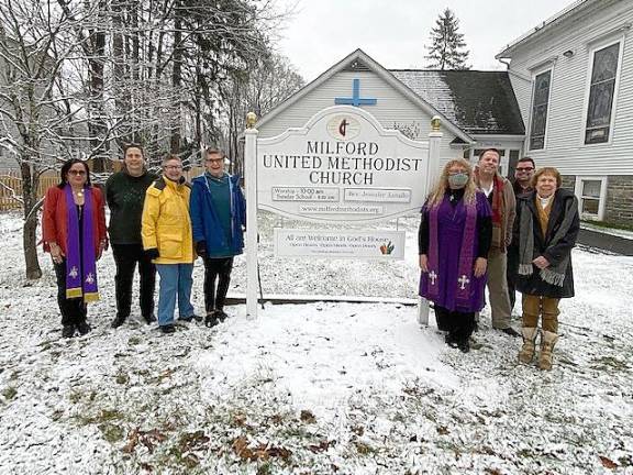 Rev. Dr. Eunice Vega-Perez far left, church pastor Rev. Jenn Lovallo just to the right of the sign, the Reconciling Ministries Team