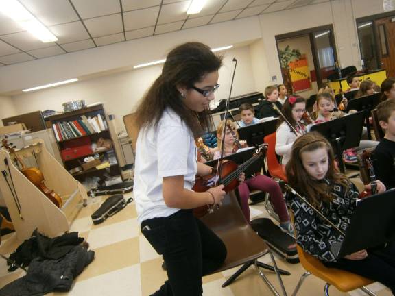Orchestra students learn by mentoring Pictured in the front row (from left): Sydney Cadogan and Trenady C. (Photo provided)