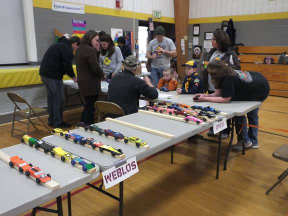 Race Time at the Pinewood Derby Photos by George LeRoy Hunter Race cars on display as entrants register.