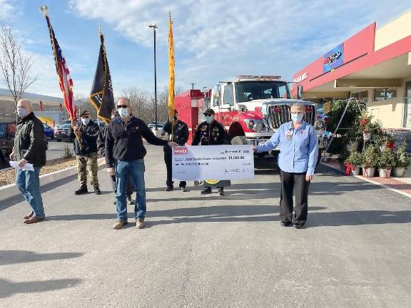 Dennis Curtin (left), director of public relations, Weis Markets; Vietnam Veterans of America, Tri-State Chapter 623; and Amy Zimmerman, store manager, and a store employee holding replica of one of the checks donated to the community groups (Photo by Marilyn Rosenthal)