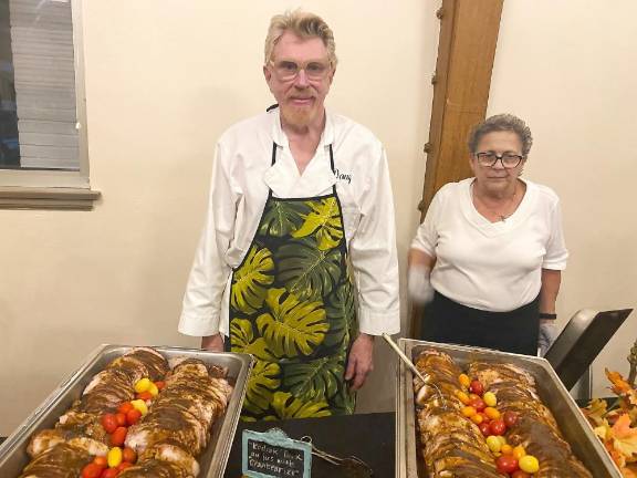 Caterer Doug Cosh with Maria Leone serving the dinner