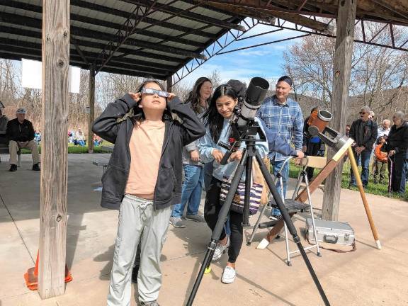 Residents gather to view partial solar eclipse Noah Tymczyszyn, 10, of Warwick, N.Y., looks at the partial solar eclipse through safety glasses as his mother, Cat, uses a telescope set up at the Wallkill River National Wildlife Refuge in Sussex. (Photo by Kathy Shwiff)