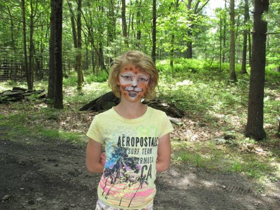 All creatures great and small Hannah Chappell with a pretty, smiling, lion painted face.