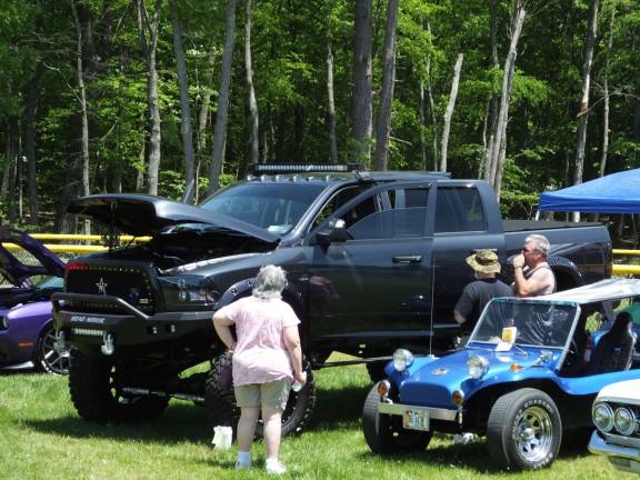 The cars are the stars at 'Cruise in the Park' Stephen Butyn of Milford (far right) talks to visitors about his tricked-out 2015 Ram 3500 4x4 pickup truck. The suped-up truck attracted a lot of attention and won third place in the Mopar category.
