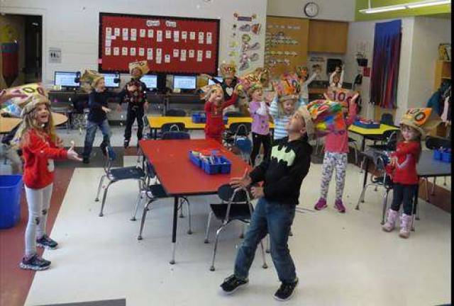 Mrs. Stewart&#x2019;s kindergarten class throws 100th Day confetti (Photo by Peg Snure)